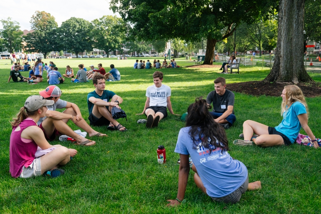 students sitting in circle on grass