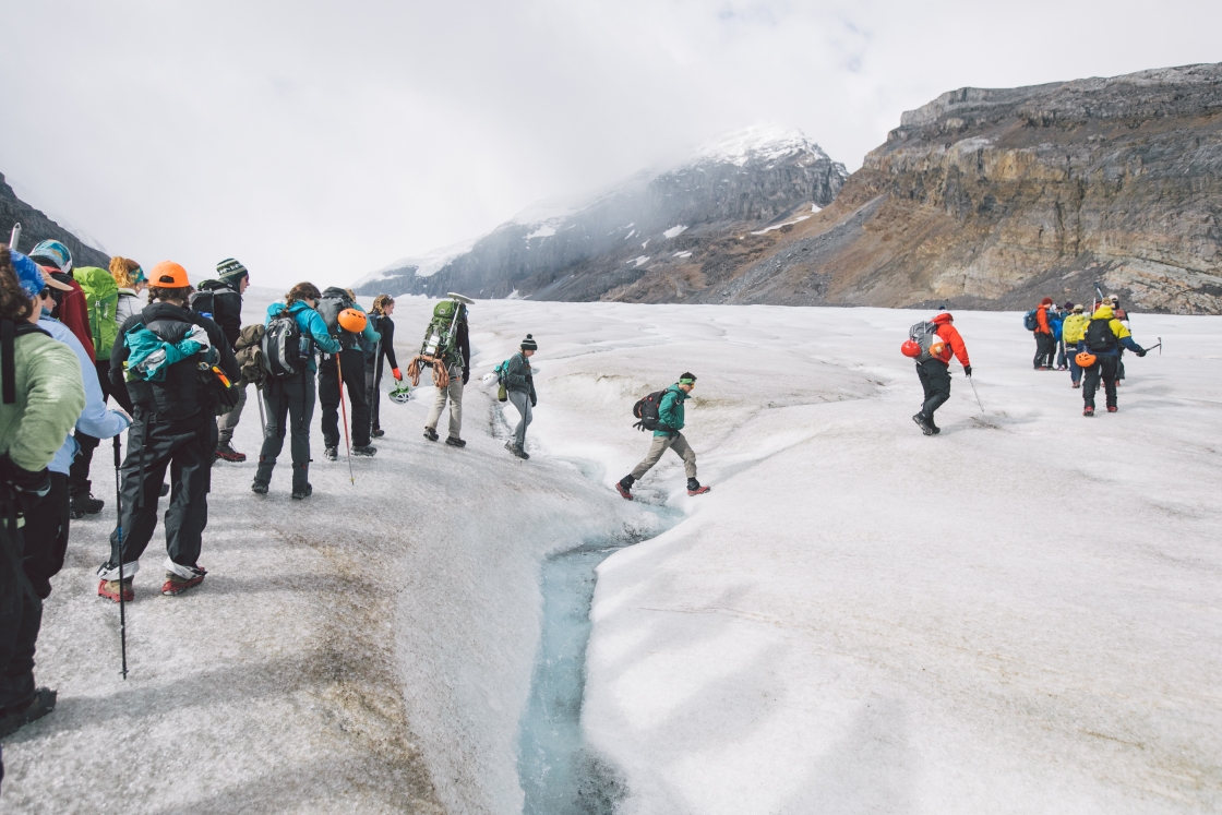 Students crossing a glacial stream on the Athabasca Glacier.