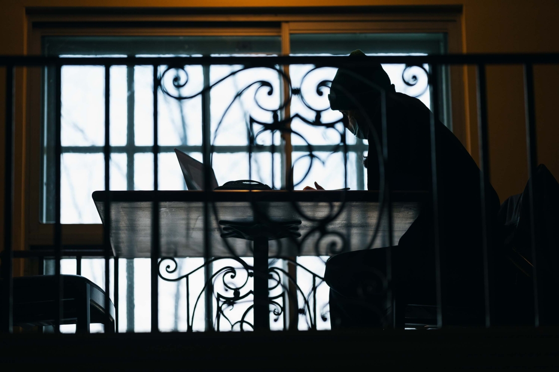 Silhouette of person studying in front of Dartmouth wrought iron gate