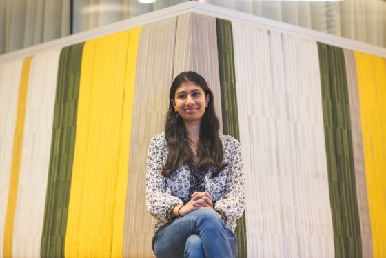 Adithi Jayaraman '24 poses in front of a striped curtain