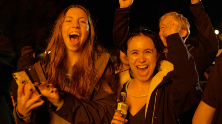 Two students smile during the Homecoming bonfire