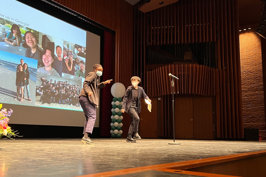 Two masked students presenting onstage