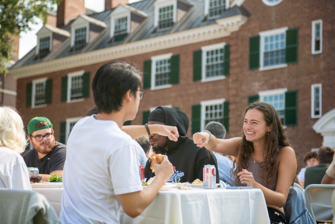 Two students fist bump at the Dartmouth community cookout