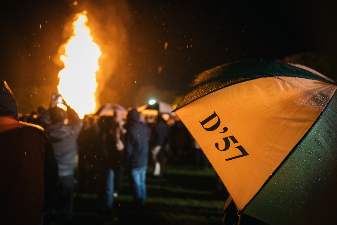Alumni umbrella during the bonfire