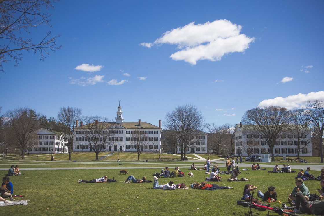 Students lounge on the Dartmouth Green in front of Dartmouth Hall