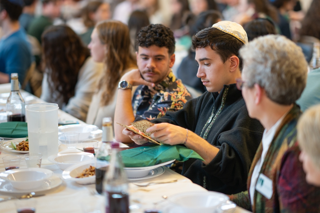 A student breaks the middle matzah during the seder