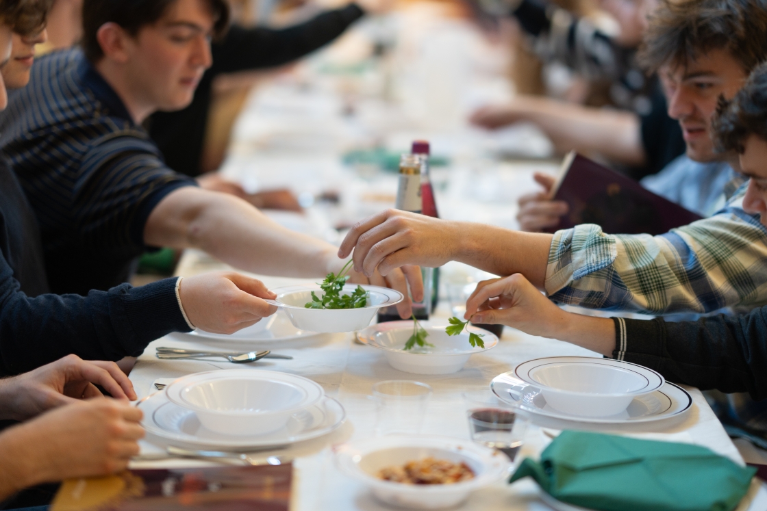 Parsley is passed among the students attending Passover