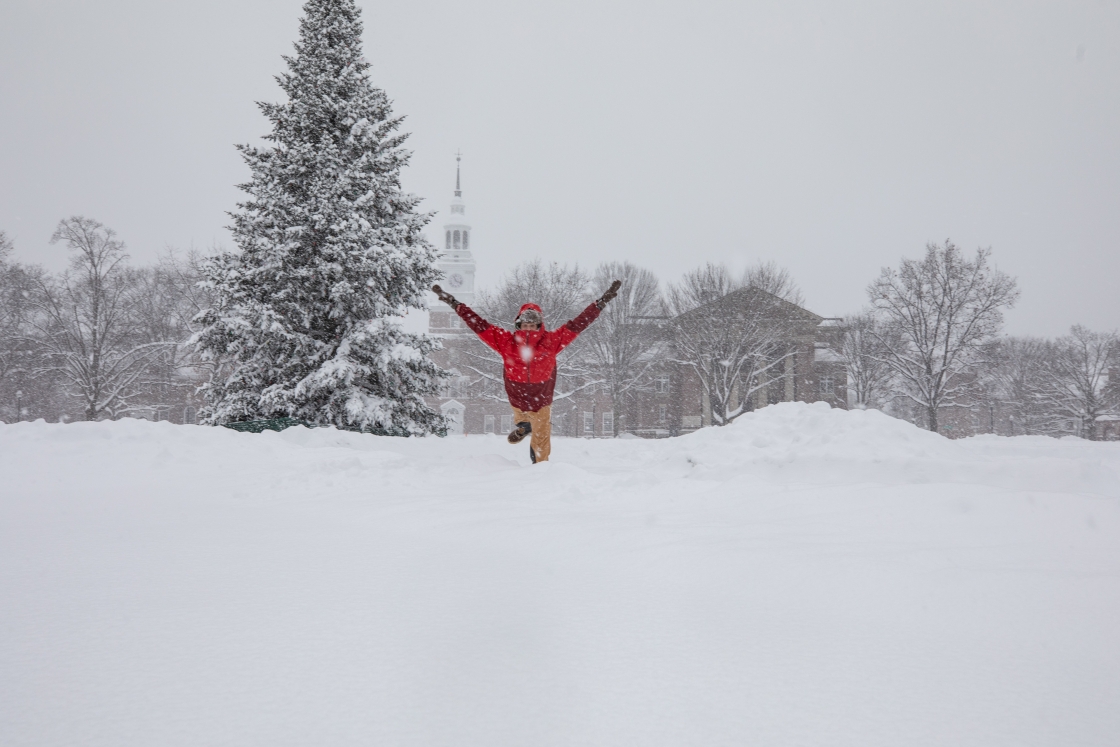 Student jumps in excitement over the first snow of the season at Dartmouth on December 16, 2020