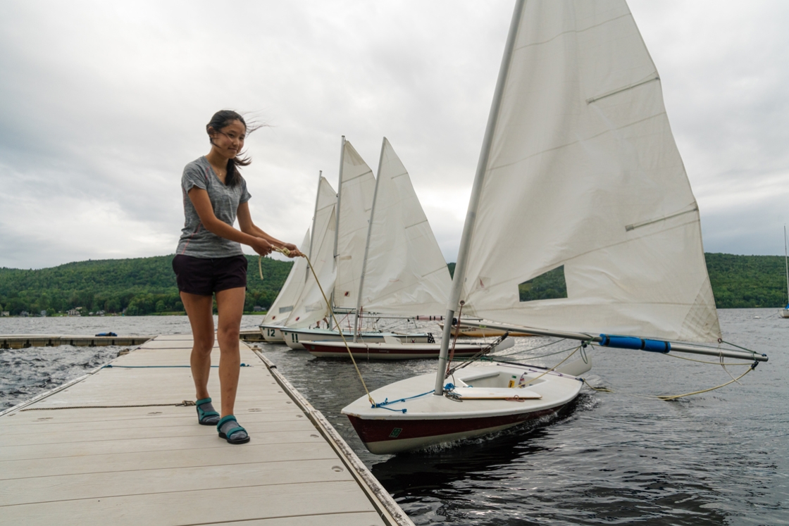 On Lake Mascoma, Zoe Chen ’23 pulls in a boat on a windy day during her Dartmouth Outing Club first year trip.