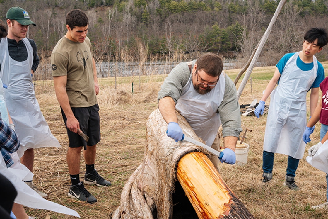 Art Hanchett, center, demonstrates how to process a moose hide in an “Encountering Forests” lab.