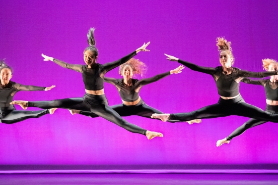 Members of dance troupe Sugar Plum performing against a fuchsia background