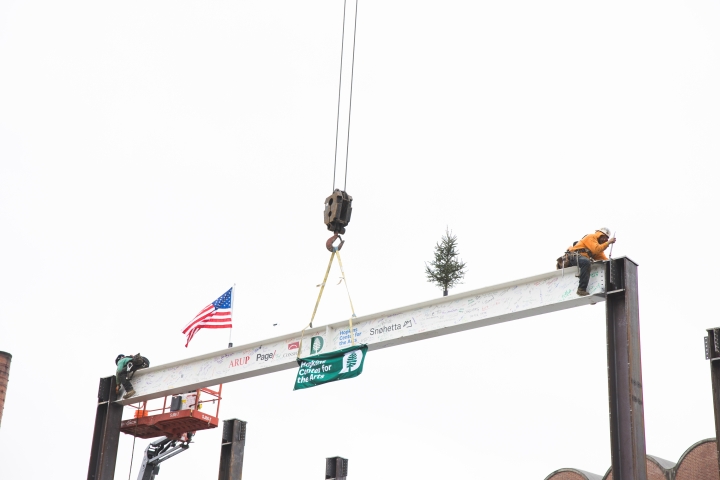 Construction workers secure the steel beam