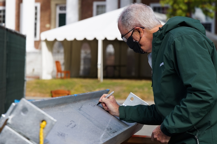 President Philip J. Hanlon '77 signs his name to the final beam.