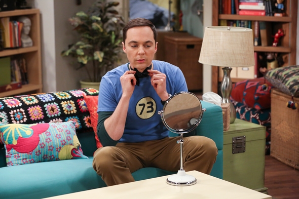 A character from The Big Bang Theory sits on a couch
